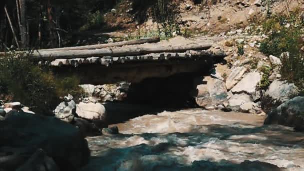 Drewniany most przez burzliwą górską rzekę — Wideo stockowe