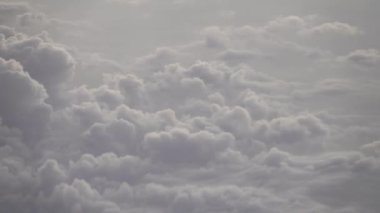 Koyun gibi bulutlar uçağın kanatları altında