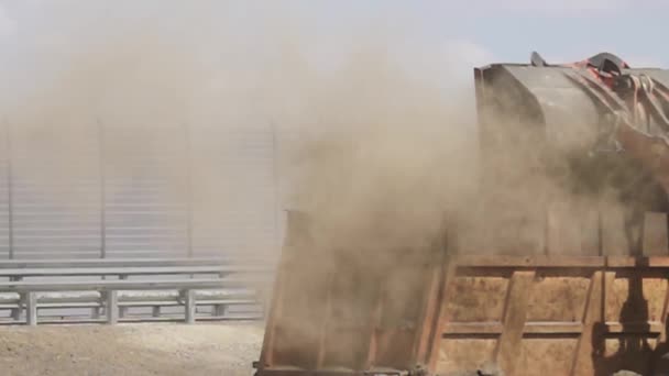 Schraper met giet stoffige aarde in de achterkant van dump truck — Stockvideo