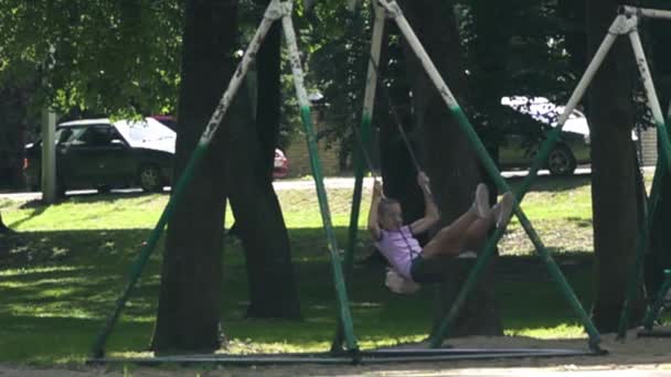 Girl swings on a swing — Stock Video