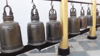 Büyük ve küçük el zilleri olan duvar.