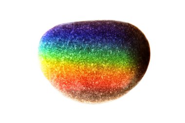 Zen stone in touch of rays of color. The concept of maximum joy from color