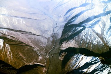 Kuş bakışı parlak bir hüzün kaynağı. Parlak karlı tepeler, derin vadiler ve buzullar.