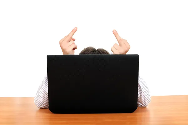 Långfingret bakom laptop — Stockfoto