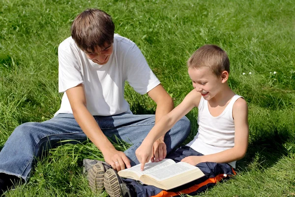 Adolescent et enfant lit livre — Photo