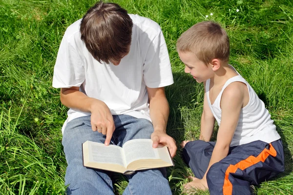 Tinédzser és gyerek elolvassa a könyvet — Stock Fotó