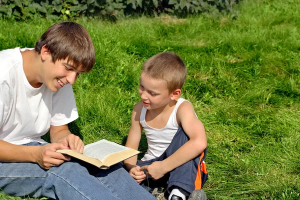 Teenager And Kid Reads Book — Stock Photo, Image