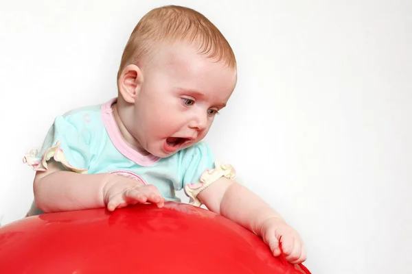 Bebê em uma bola vermelha — Fotografia de Stock