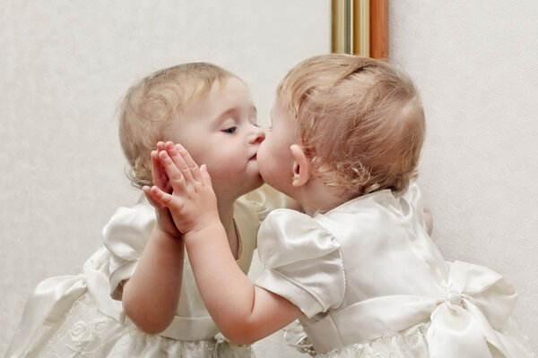 Ребенок целует зеркало
