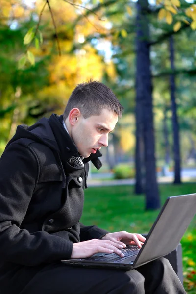 Homem com laptop no parque — Fotografia de Stock