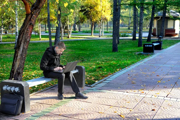 Man med bärbar dator i parken — Stockfoto