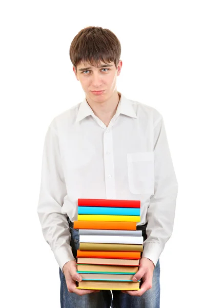 Печальный студент держит в руках стопку книг — стоковое фото