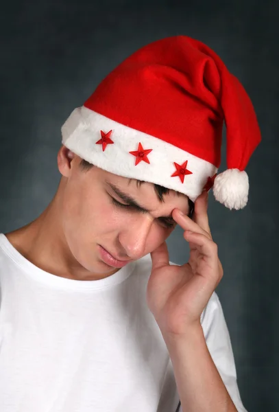 Smutný teenager v santas klobouk — Stock fotografie