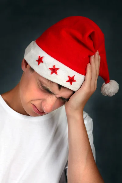 Teenager v santa hat cítí bolest hlavy — Stock fotografie