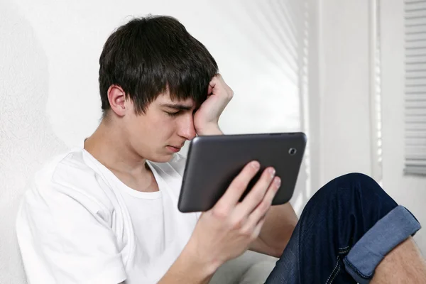 Tablet ile üzgün bir genç adam — Stok fotoğraf