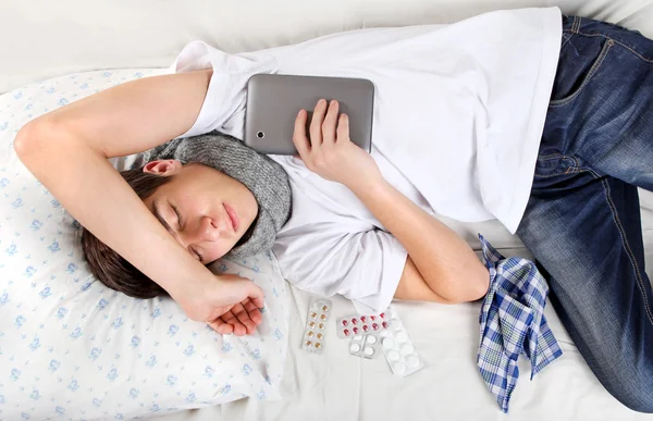Tablet bilgisayar ile genç adam uyuyor — Stok fotoğraf