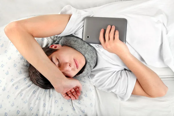 Молодой человек спит с планшетным компьютером — стоковое фото