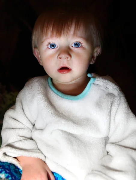 Verrast babyjongen in het donker — Stockfoto