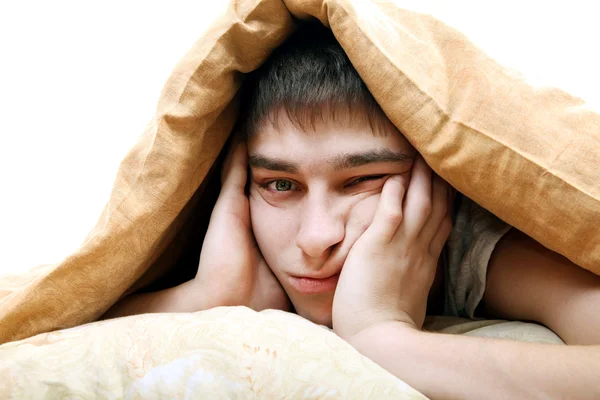 Entediado adolescente sob cobertor — Fotografia de Stock
