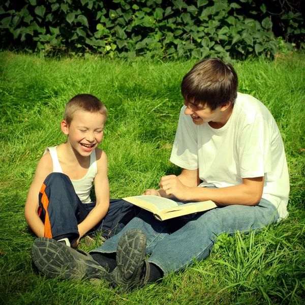 Genç ve çocuk bir kitapla — Stok fotoğraf