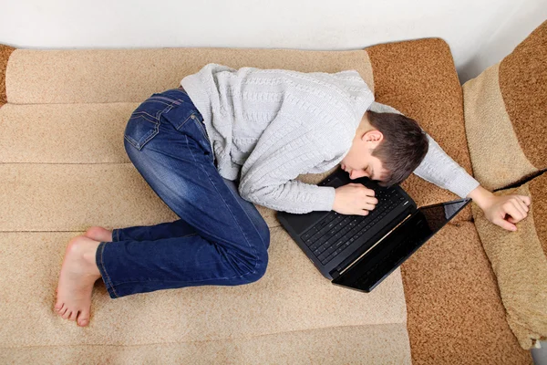 Adolescente duerme en el ordenador portátil —  Fotos de Stock