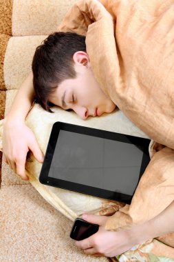 tablet bilgisayar ile genç uyur