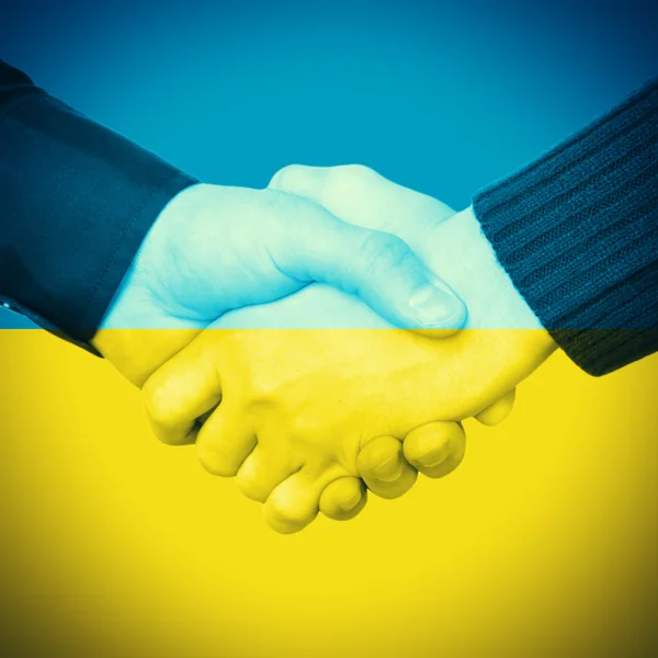 Händedruck und ukrainische Flagge — Stockfoto