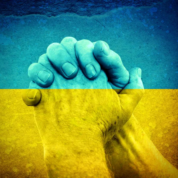 Händer på ukrainska flagga — Stockfoto