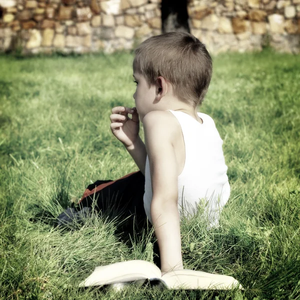 Gelangweilter Junge mit einem Buch — Stockfoto