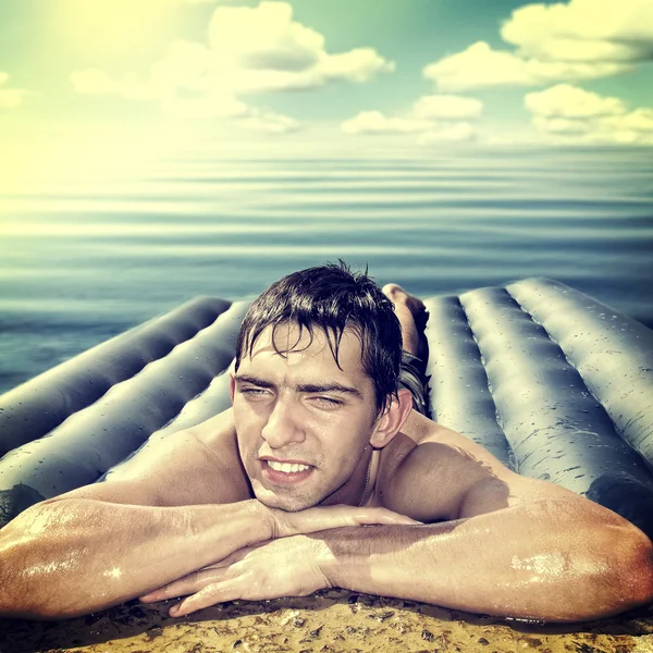 Mężczyzna na plaży materac — Zdjęcie stockowe