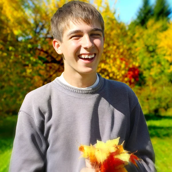 Подросток с осенними листьями — стоковое фото