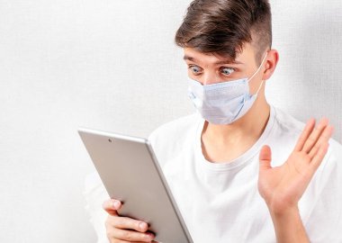 Grip Maskeli Şaşkın Genç Adam Video Sohbeti için Tablet Bilgisayar kullanıyor