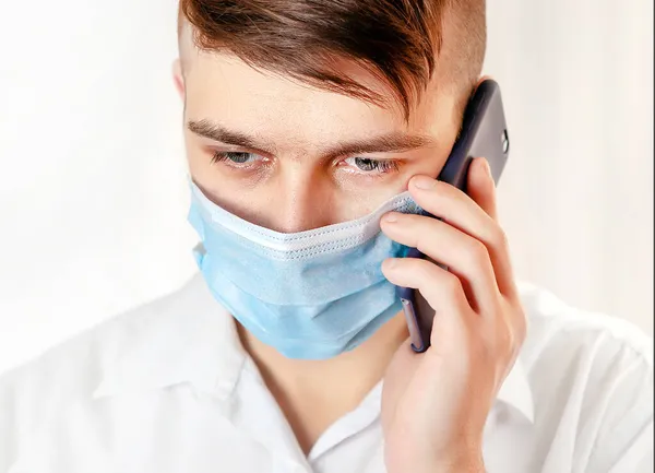 Grip Maskeli Endişeli Genç Adam Duvar Yanında Cep Telefonu Tutuyor — Stok fotoğraf
