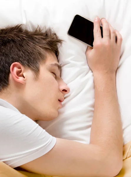 Młody Człowiek Śpi Łóżku Telefonem Komórkowym — Zdjęcie stockowe