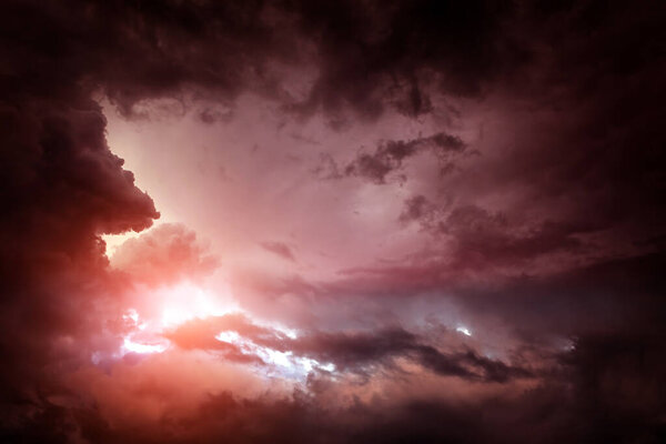 Light in the Red Dark and Dramatic Storm Clouds