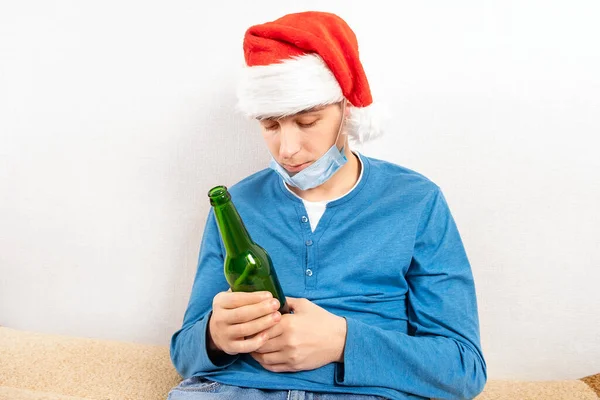 Giovane Uomo Santa Hat Maschera Influenzale Con Una Bottiglia Birra — Foto Stock