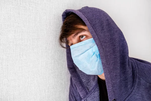 Trauriger Junger Mann Kapuzenpulli Mit Grippemaske Der Wand Zimmer — Stockfoto