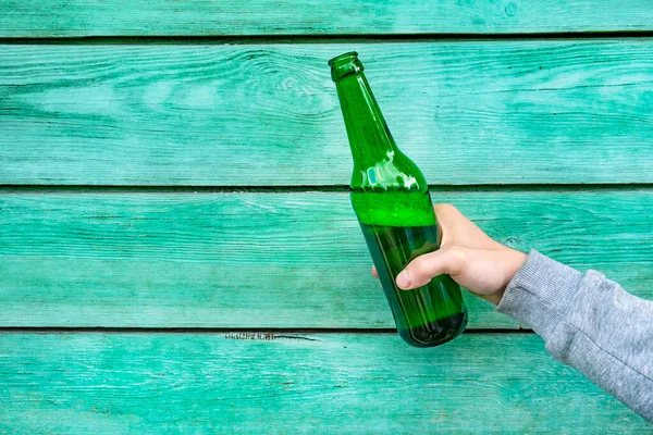 Person Hält Eine Flasche Bier Der Grünen Hölzernen Wand — Stockfoto