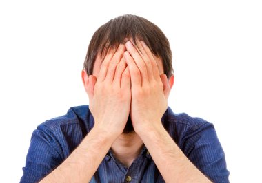 Mutsuz genç adam, beyaz arka planda elleri olan yüzü kapat.