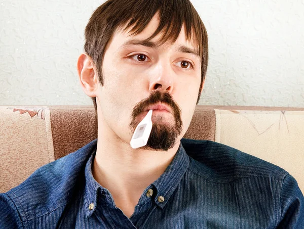 Kranker Mann Mit Thermometer Auf Dem Heimischen Sofa — Stockfoto