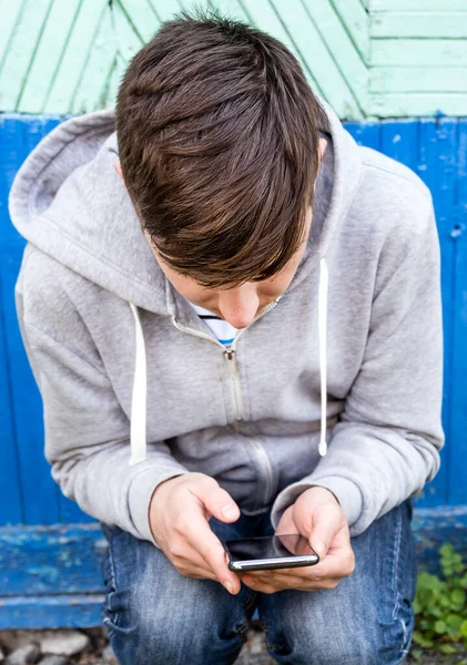 Giovane Sedersi Con Telefono Sul Vecchio Muro Sfondo All Aperto — Foto Stock