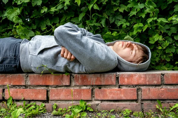 Giovane Uomo Con Una Felpa Con Cappuccio Dormire Sul Marciapiede — Foto Stock