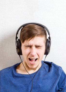 Kulaklıkmutlu Genç Adam Duvar tarafından Müzik dinlemek