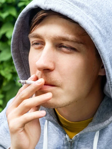 Young Man Smoke Cigarette Portrait Green Leaves Background Closeup — Stockfoto
