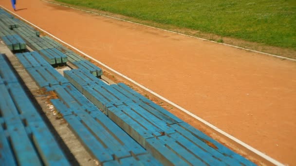 Ung man kör i stadium spår — Stockvideo