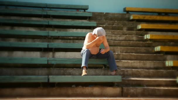 Jeune homme traversant la piste du stade — Video