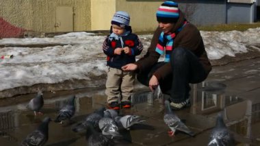 Anne ve genç çocuk güvercin besleme