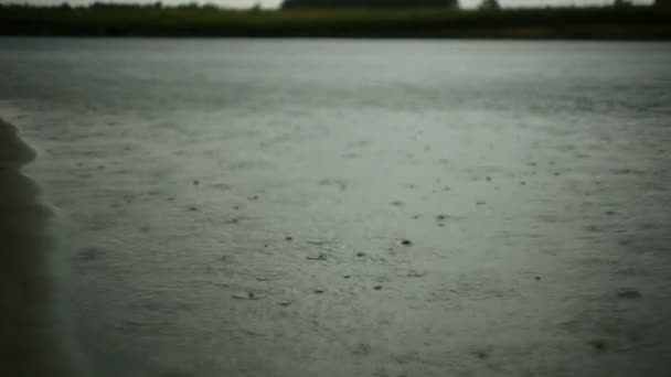 Gotas de lluvia cayendo sobre el agua — Vídeos de Stock