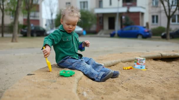 Bambino piccolo che gioca nella sabbiera — Video Stock