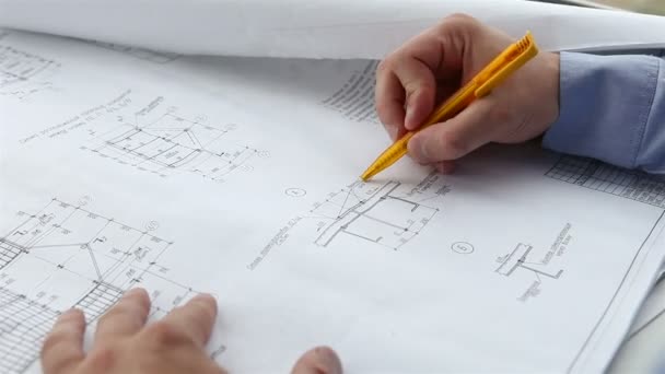 Ingeniero comprueba los dibujos de construcción — Vídeo de stock